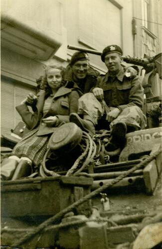 Jonge vrouw en twee soldaten op een tank