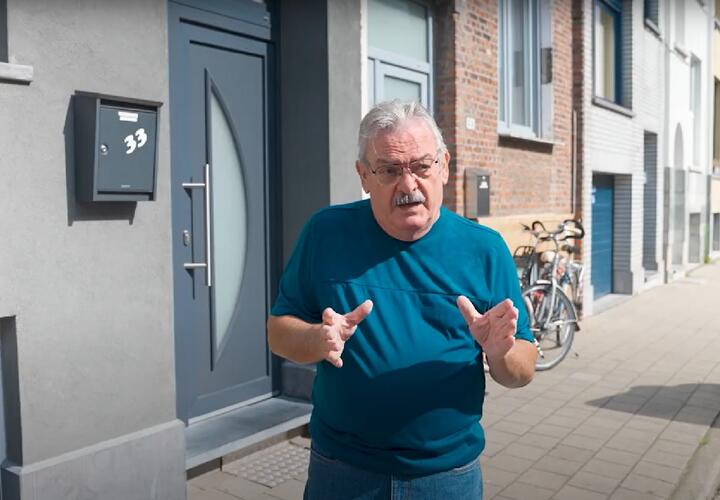Man staat op straat en beeldt iets uit met zijn handen
