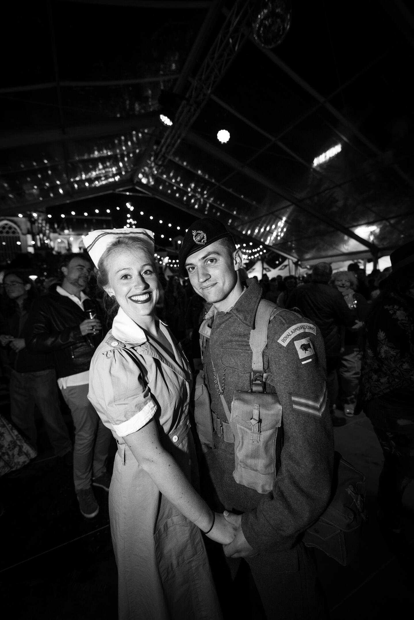 Vrouw en man in soldatenuniform poseren op een feest.