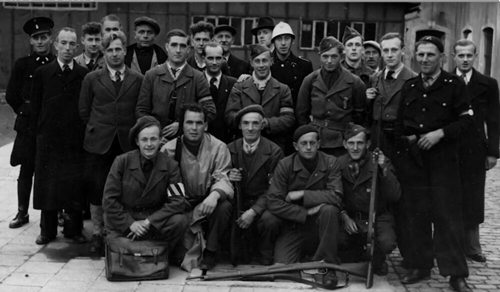 Een groep mensen poseert op een zwart-witfoto.