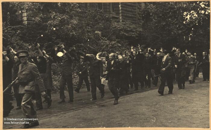 Een stoet van mensen die worden bewaakt door anderen