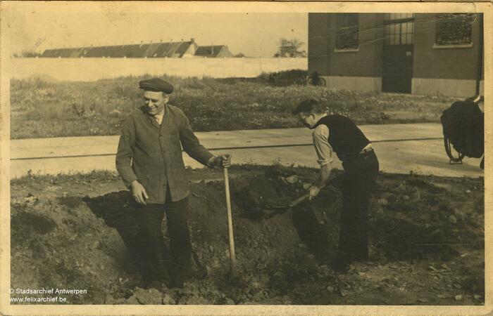 Twee mannen bewerken met een schop de akker