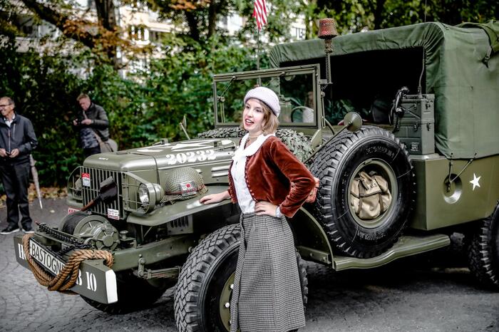 Een dame poseert voor een legertank