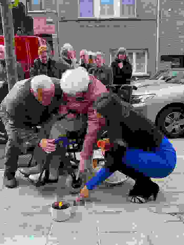 3 personen wijzen naar plaatje op de grond