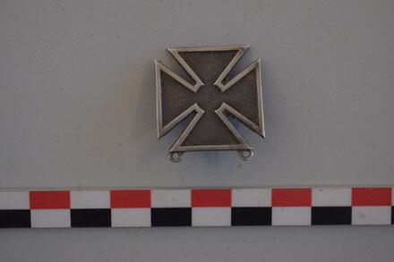 Een militair insigne in kruisvorm.