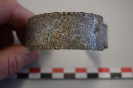 Een metalen armband waarin enkele landen werden gegraveerd.