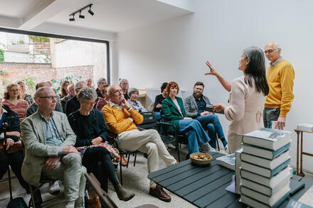 vrouw en man staan voor een zittend publiek
