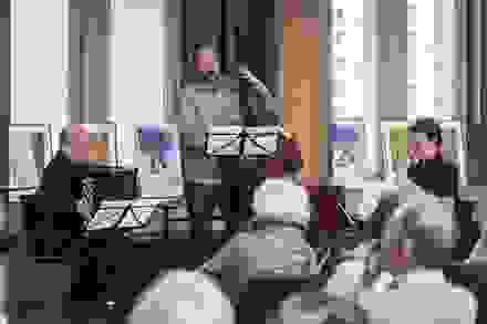 man met accordeon, man met contrabas, zittende mensen