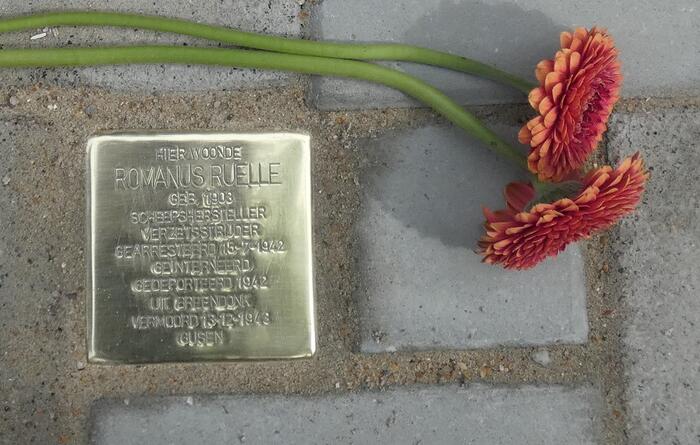 Gedenkplaatje voor Romain Ruelle met 2 bloemen