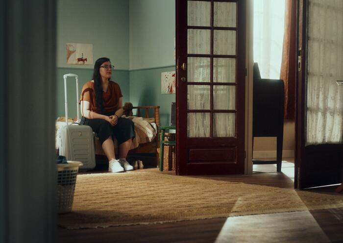 Jonge vrouw gezeten met reiskoffer