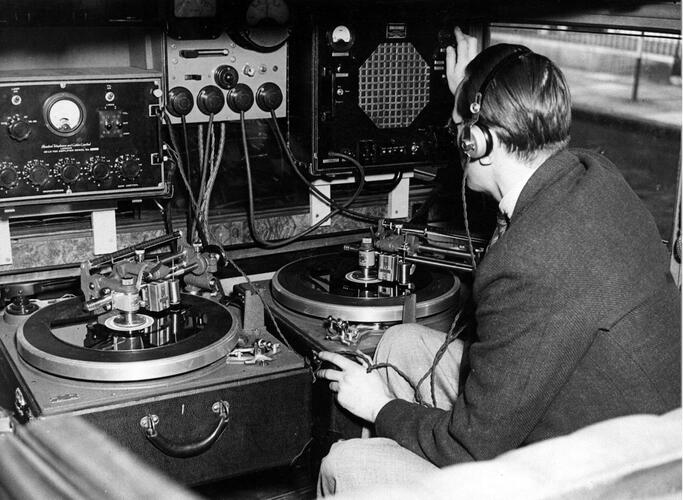 Man zit met koptelefoon aan technische installatie