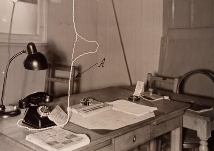 Bureau met onder meer lamp en telefoon. Stoel