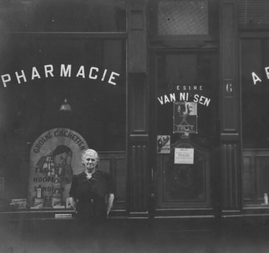 Persoon voor gevel met opschrift 'pharmacie'