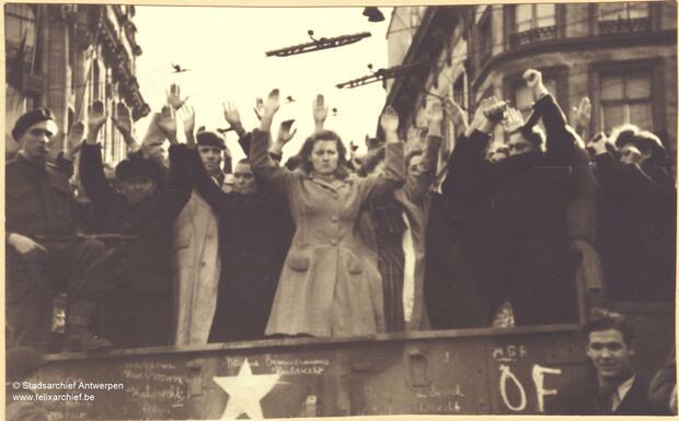 Groep mensen staan met handen in de lucht